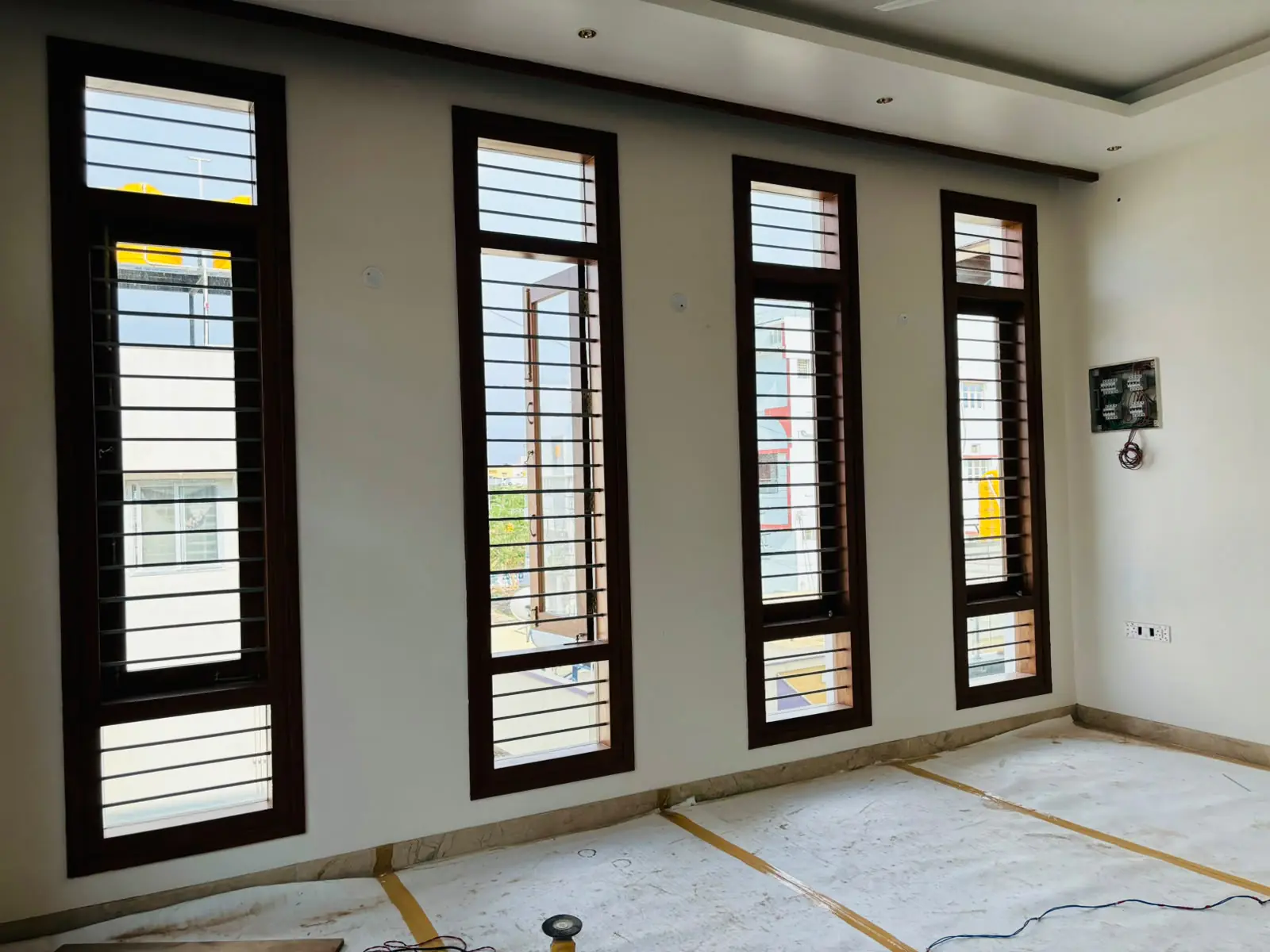A wall of four tall timber-framed windows with horizontal bars, each with a ventilator above and a fixed pane below