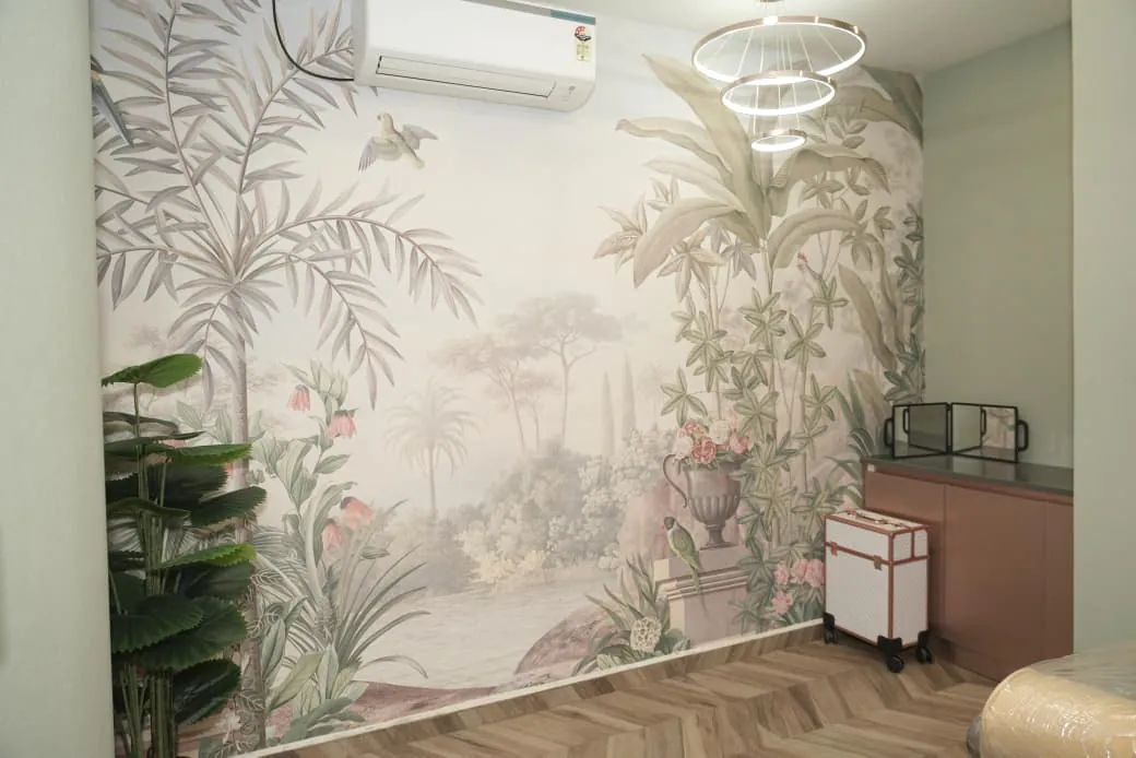 A room with a garden mural across one full wall, a ring chandelier and a low counter