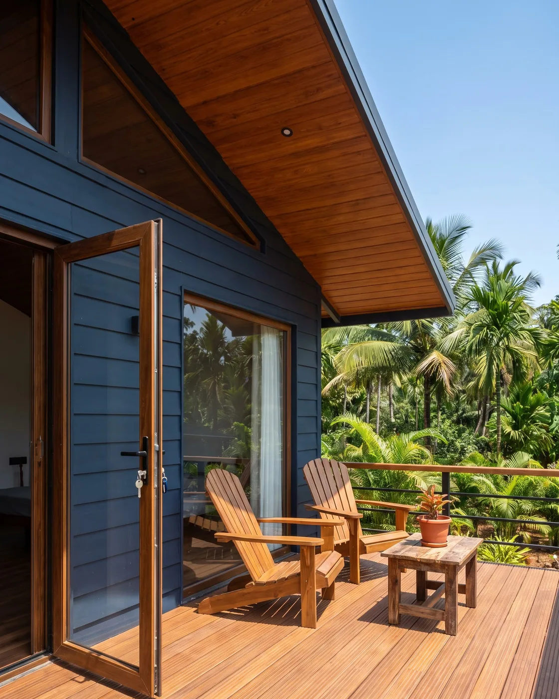 The finished deck of the cabin with two chairs and a small table, the glass door open