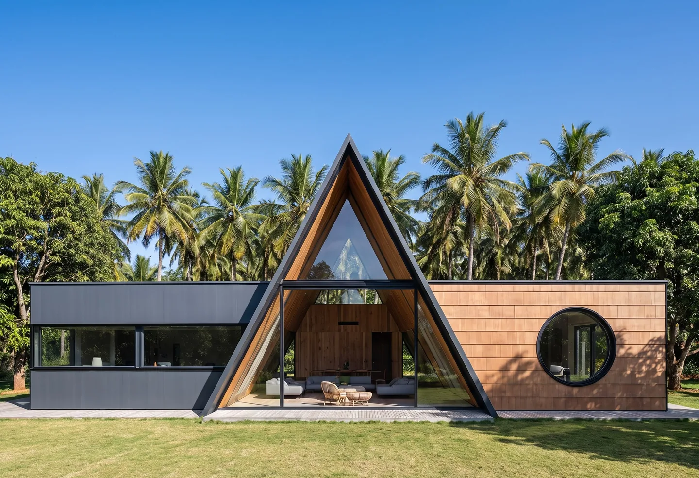 A long single-storey villa with a glazed A-frame at its centre and a flat-roofed wing on each side
